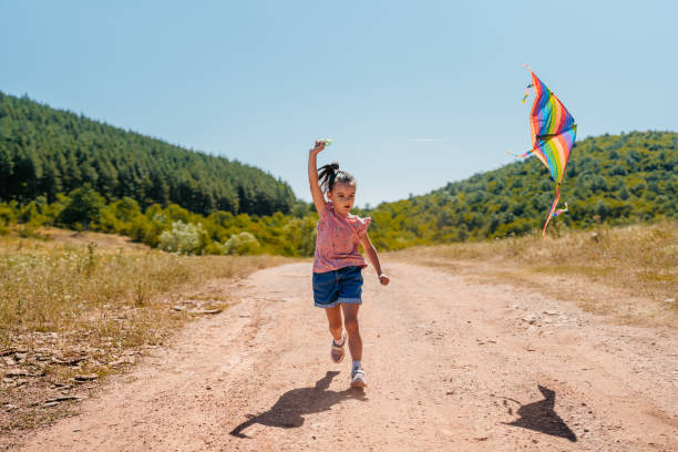 istock Elementary Age Girl Playing With A Kite On The Mountain 2171686134
