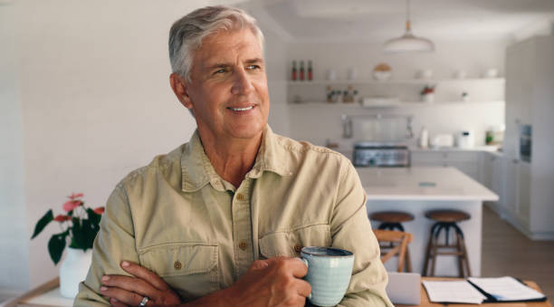 istock Mature man, home and arms crossed for thinking with coffee for break on remote work as freelance writer. Male person, living room and happy or smile with cup of tea for story and novel idea as author 2171687557