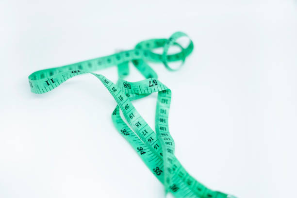 istock Green spiral measuring tape isolated on white background 2171688064