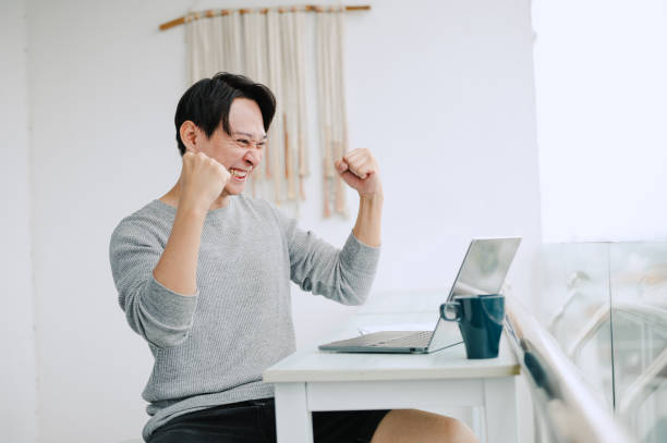istock Asian using laptop and screaming of joy at the balcony. 2171691882
