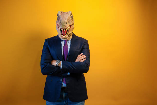 istock A man wearing a dinosaur mask and suit on a yellow background. 2171692548
