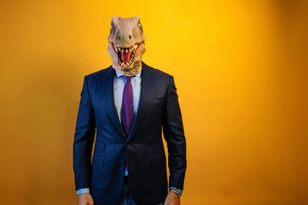 istock A man wearing a dinosaur mask and suit on a yellow background. 2171692553
