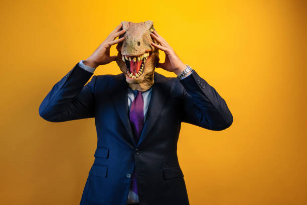 istock A man wearing a dinosaur mask with his hands on his head. 2171692554