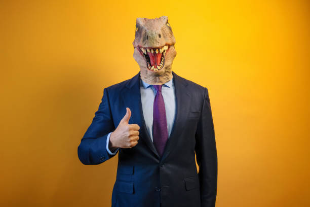 istock A man wearing a dinosaur mask showing thumb up on yellow background. 2171692580
