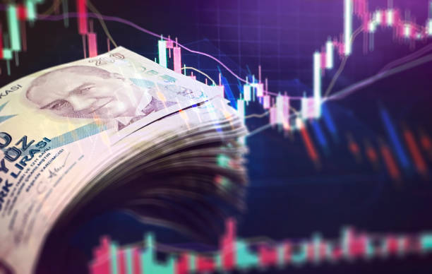 Human hand holding 200 TL banknotes on financial chart background (Depth of Field)