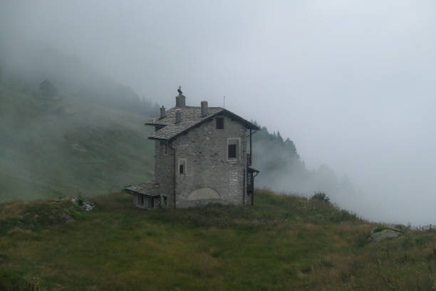 istock Small alpine house in the fog 2171696920