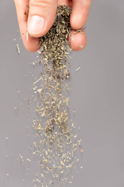 istock Hand pouring dried chopped basil, seasoning, spice 2171699071