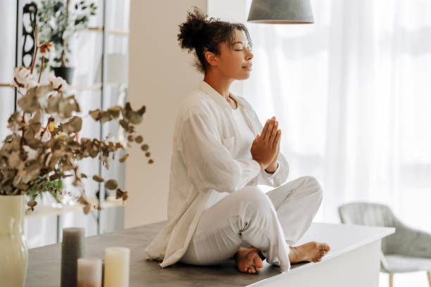 Young woman practicing yoga meditation at home on a table
