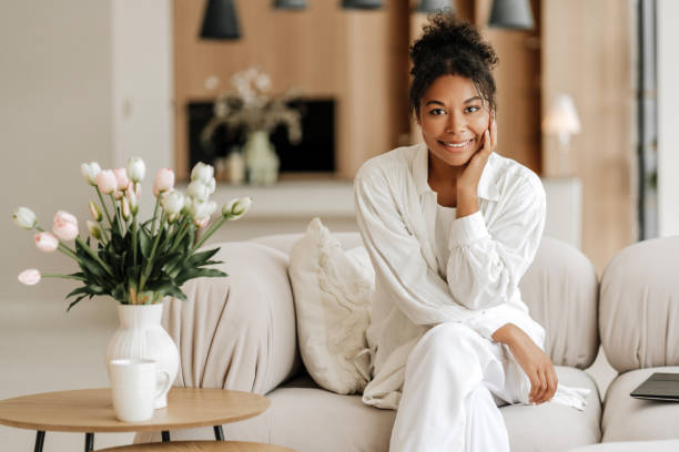 Young woman relaxing on sofa at home smiling at camera