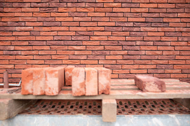 a new House is being built, the beginning of brickwork with red bricks, building materials, a pattern of stones, a natural background. High quality photo