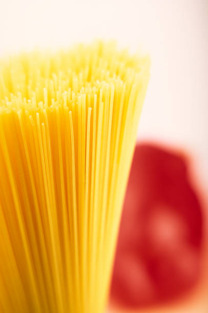 Spaghetti on blurred red salad pepper background. Food. Cover.