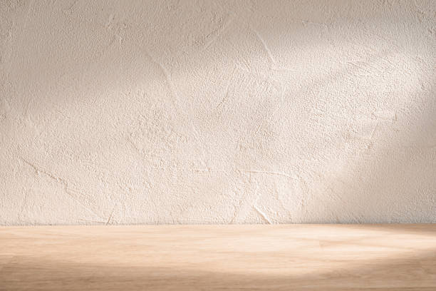 istock Minimalist wooden surface with textured wall background, softly lit, ideal for displaying products or creating a serene atmosphere 2171705710