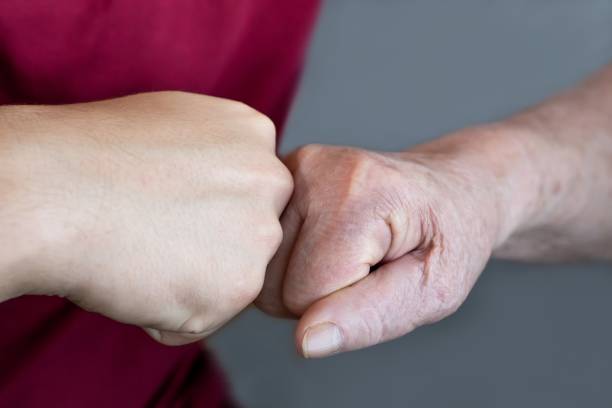 istock Greeting a young and old person with a fist bump gesture, connection, teamwork 2171710622