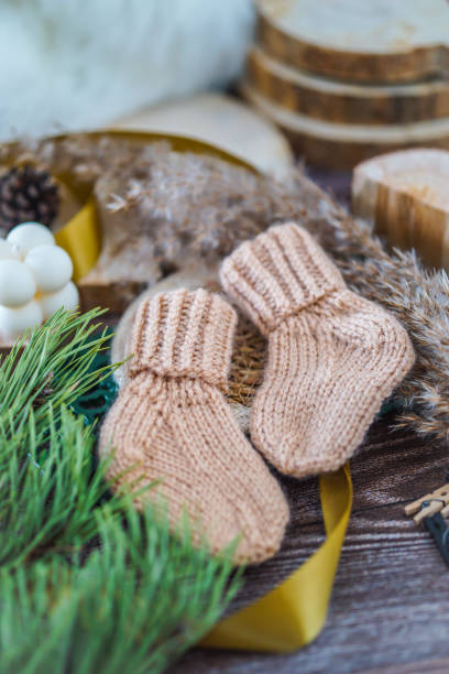 istock Brown woolen baby socks, on wooden backgound 2171712539