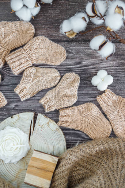 istock Brown woolen baby socks, on wooden backgound 2171712548