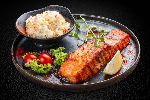 Salmon steak with creamy rice. A succulent salmon fillet, perfectly grilled or pan-seared, served alongside a bed of rich, creamy rice.