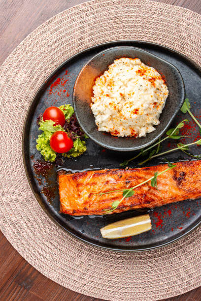 Salmon steak with creamy rice. A succulent salmon fillet, perfectly grilled or pan-seared, served alongside a bed of rich, creamy rice.