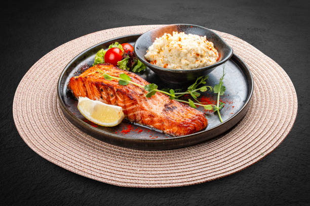 Salmon steak with creamy rice. A succulent salmon fillet, perfectly grilled or pan-seared, served alongside a bed of rich, creamy rice.