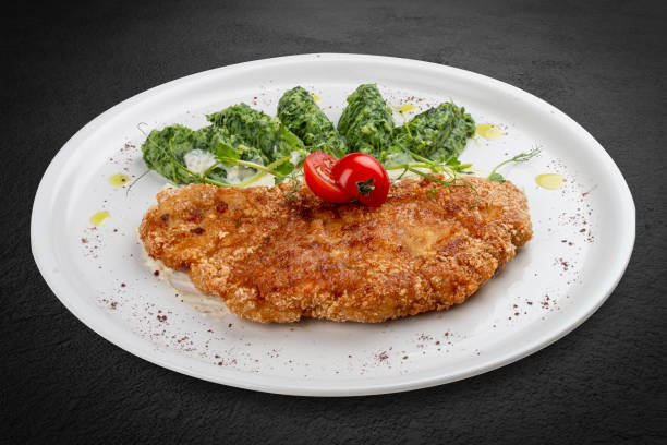 istock Chicken schnitzel served with sauce, accompanied by broccoli and cheese fritters. 2171715712