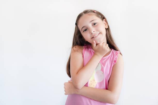 Portrait of a little schoolgirl looking away over white background