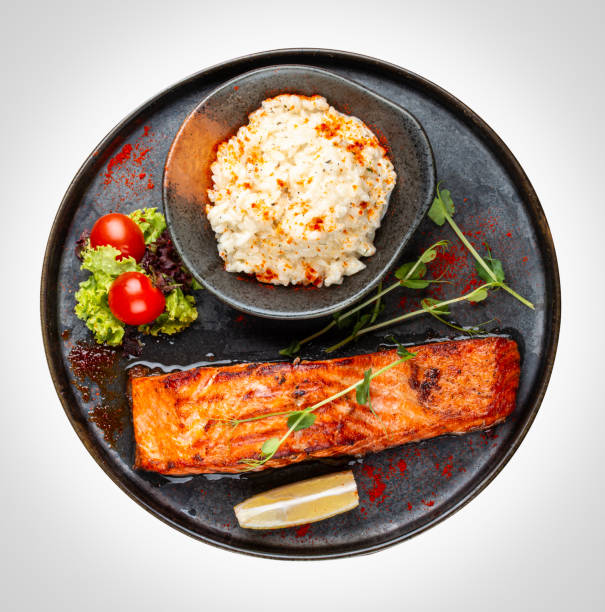 Salmon steak with creamy rice. A succulent salmon fillet, perfectly grilled or pan-seared, served alongside a bed of rich, creamy rice.