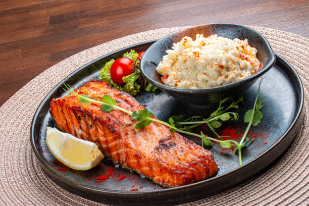 Salmon steak with creamy rice. A succulent salmon fillet, perfectly grilled or pan-seared, served alongside a bed of rich, creamy rice.