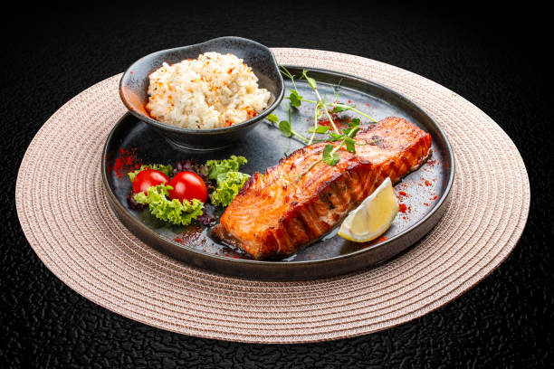Salmon steak with creamy rice. A succulent salmon fillet, perfectly grilled or pan-seared, served alongside a bed of rich, creamy rice.