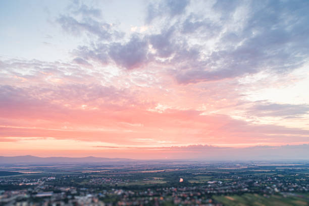 Bird's eye view of the sunset. Below are fields and villages against a dramatic, beautiful sky.