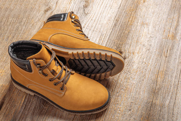istock Yellow boots on wooden background. 2171718975