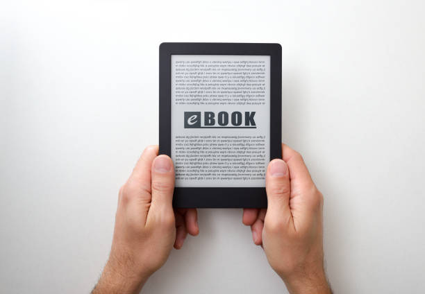 Hands holding an ebook with text on screen on white isolated table. Top view