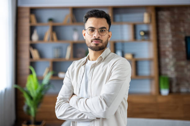 istock Confident young man standing in modern office environment with arms crossed 2171721799
