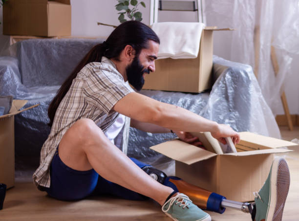 istock Happy man with prosthetic leg unpacking boxes at new home 2171724512