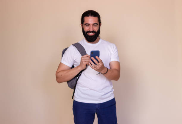 istock Young adult student is smiling while using his smartphone 2171724910