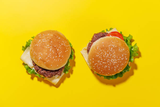 istock Hamburgers spread evenly across a bright yellow background 2171724953