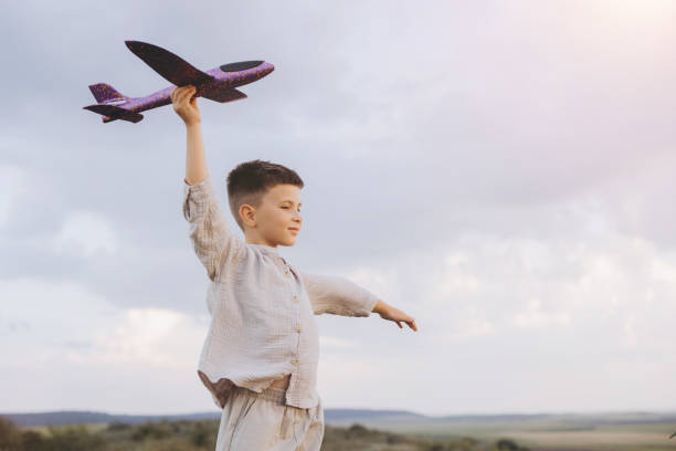 istock Child Playing with Toy Airplane Outdoors on a Cloudy Day 2171727503