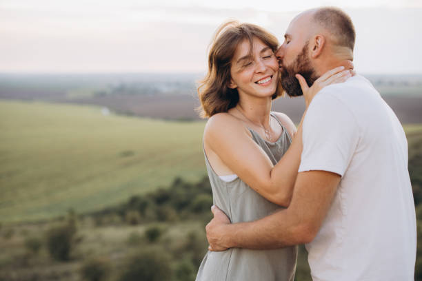 istock Romantic Couple Embracing in a Scenic Countryside Setting Against a Softly Lit Sky 2171732826