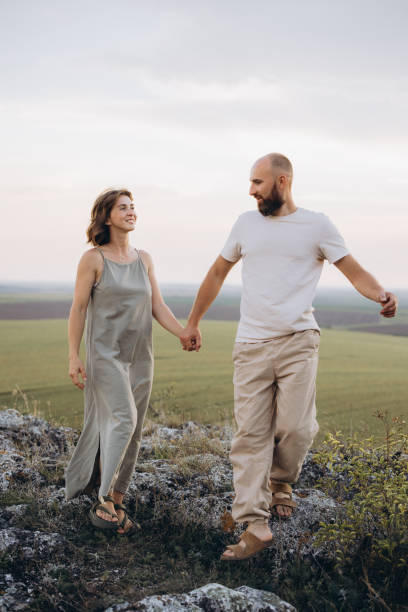 istock Couple Walking Hand in Hand on Scenic Hillside During a Serene Evening Stroll 2171732829