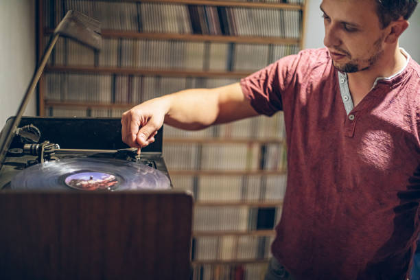 Playing vinyl on turntable record playerMan listening to music with retro turntable