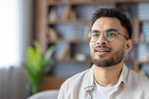 istock Hispanic man with glasses at home looking content and thoughtful in modern indoor setting 2171735243