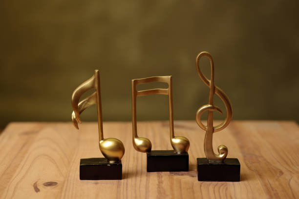 Golden music notes statuettes standing on wooden surface