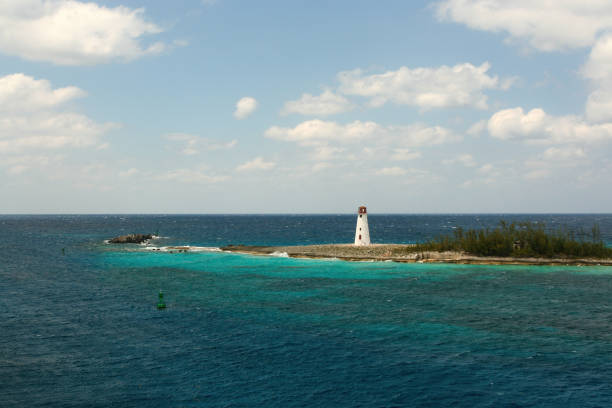 A view of the Hog Island Lighthouse in Nassau Bahamas with stormy seas surrounding it
