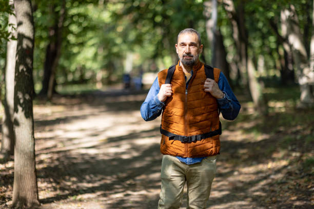 istock Man walking alone on a quiet wooded path, relaxed. 2171760799
