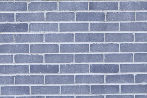 istock Walls with a rough textured plaster finish, dark grey bricks with a white grout line pattern. Background. 2171763623