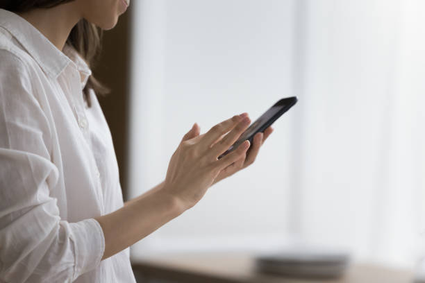 istock Female hands holding modern smartphone standing indoor 2171771460
