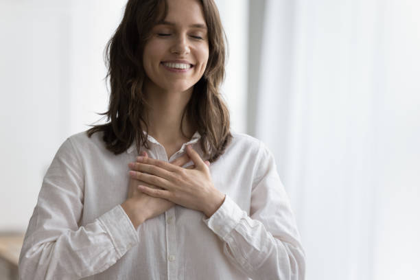 istock Lady holding folded hands on heart chest, feeling gratitude 2171772160