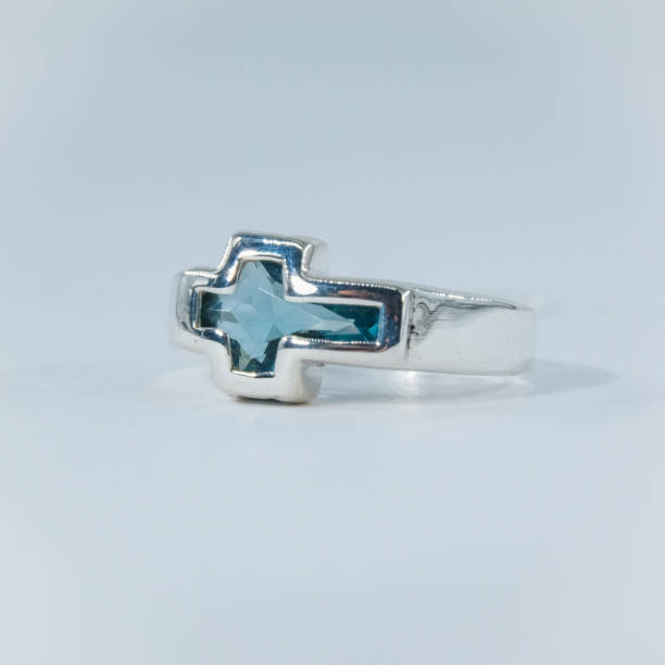 A silver ring with a cross symbol on it