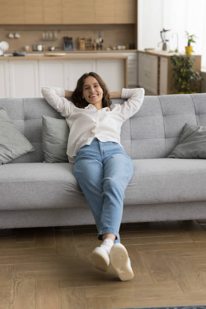 istock Pretty young woman relaxing at home leaned on cozy sofa 2171774528
