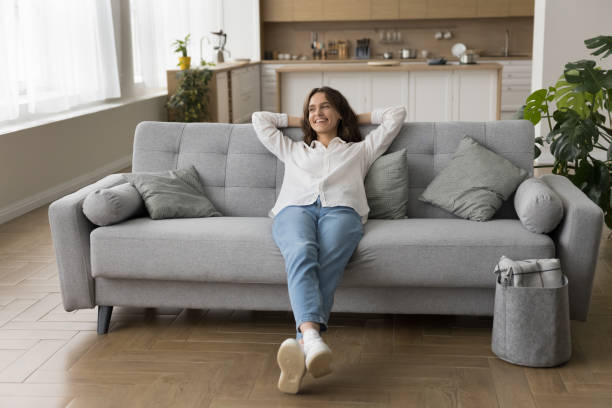 istock Millennial female lying down on sofa with hands behind head 2171776085