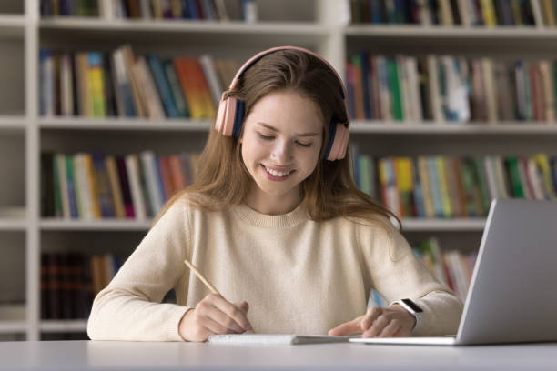 istock Cheerful student girl in bog wireless headphones watching learning webinar 2171779981