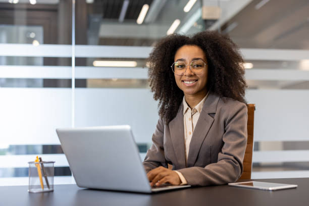 istock Confident businesswoman working on laptop in modern office setting 2171780036